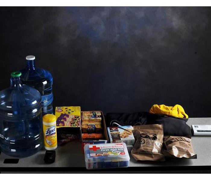 Emergency supplies such as a first aid kit, granola bars, disinfectant wipes, and fresh water bottles are shown.