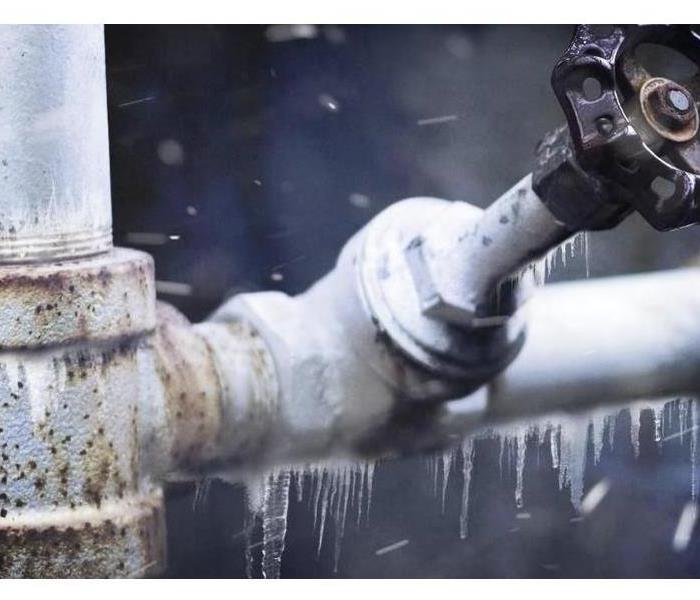 An outdoor pipe is shown covered in ice.